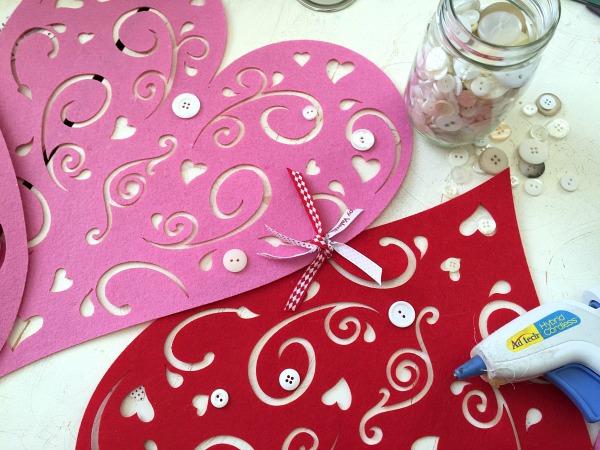 DIY No-Sew Valentine's Table Runner. Tie heart placemats together with ribbon then hot glue buttons. Easy! 