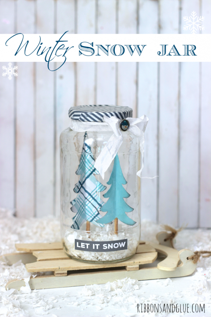DIY Winter Snow Jar made from an upcycled sauce jar, paper trees and fake snow. Creative way to bring winter in to your home without the mittens. 